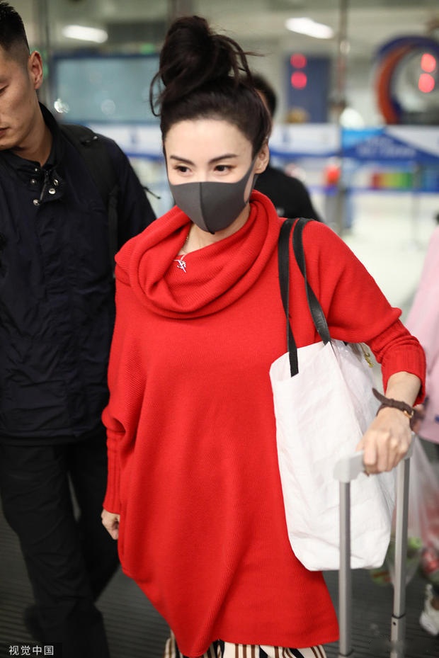 2019年5月20日,张柏芝亮相机场,她口罩遮面露出白皙肌肤,身穿红色毛衣