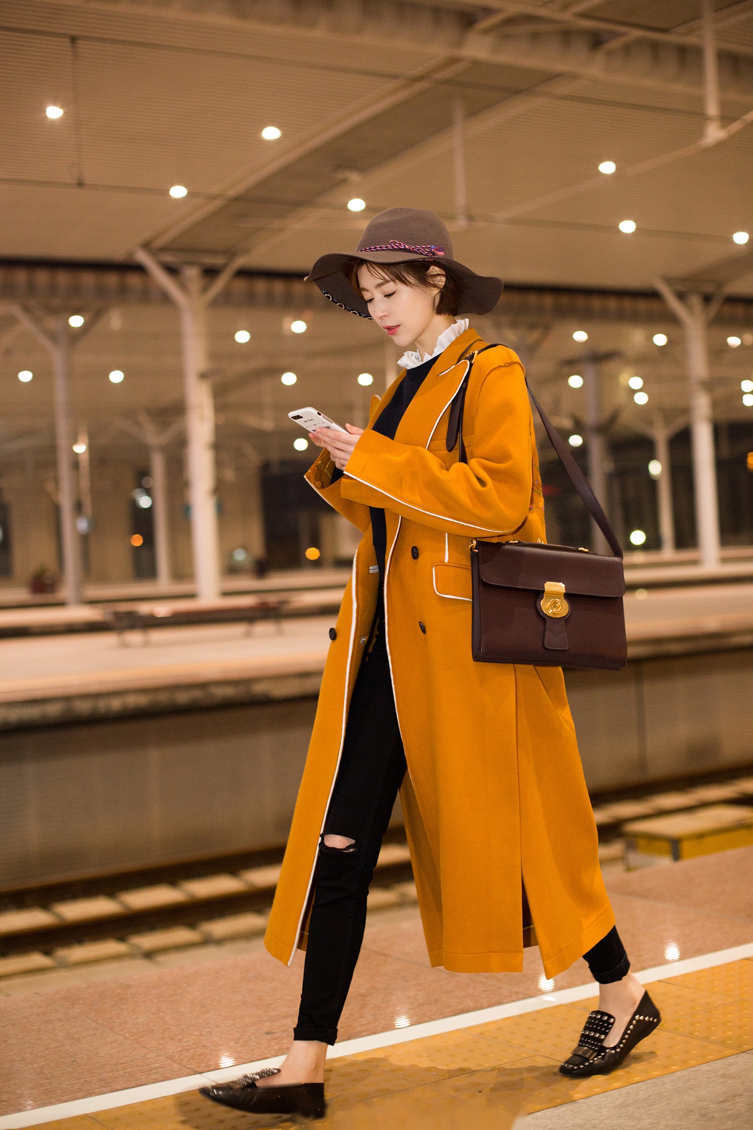 演员卢杉现身北京高铁站,身穿橘色长款毛呢大衣搭配复古公文包外加咖