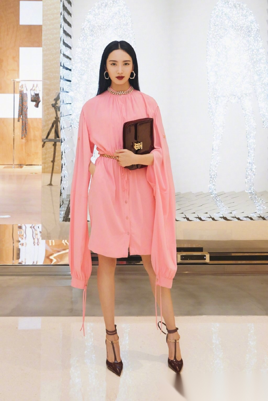 王紫璇穿着粉色丝质纱裙,利落黑发配深色红唇,好一个复古摩登的粉红