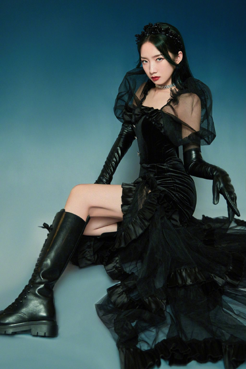 孟美岐身着黑色网纱连衣裙,搭配皮手套和长靴,戴着精致的黑色头饰