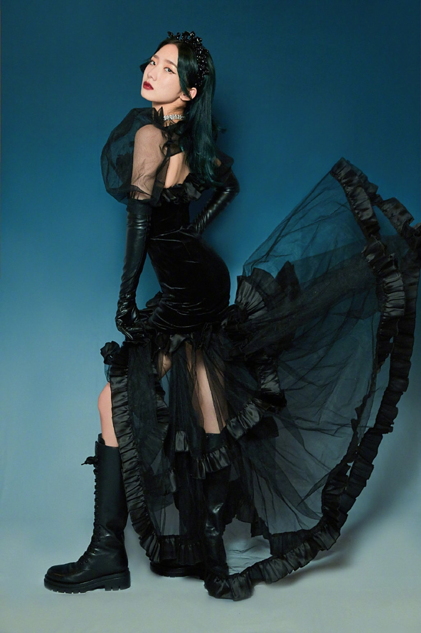 孟美岐身着黑色网纱连衣裙,搭配皮手套和长靴,戴着精致的黑色头饰