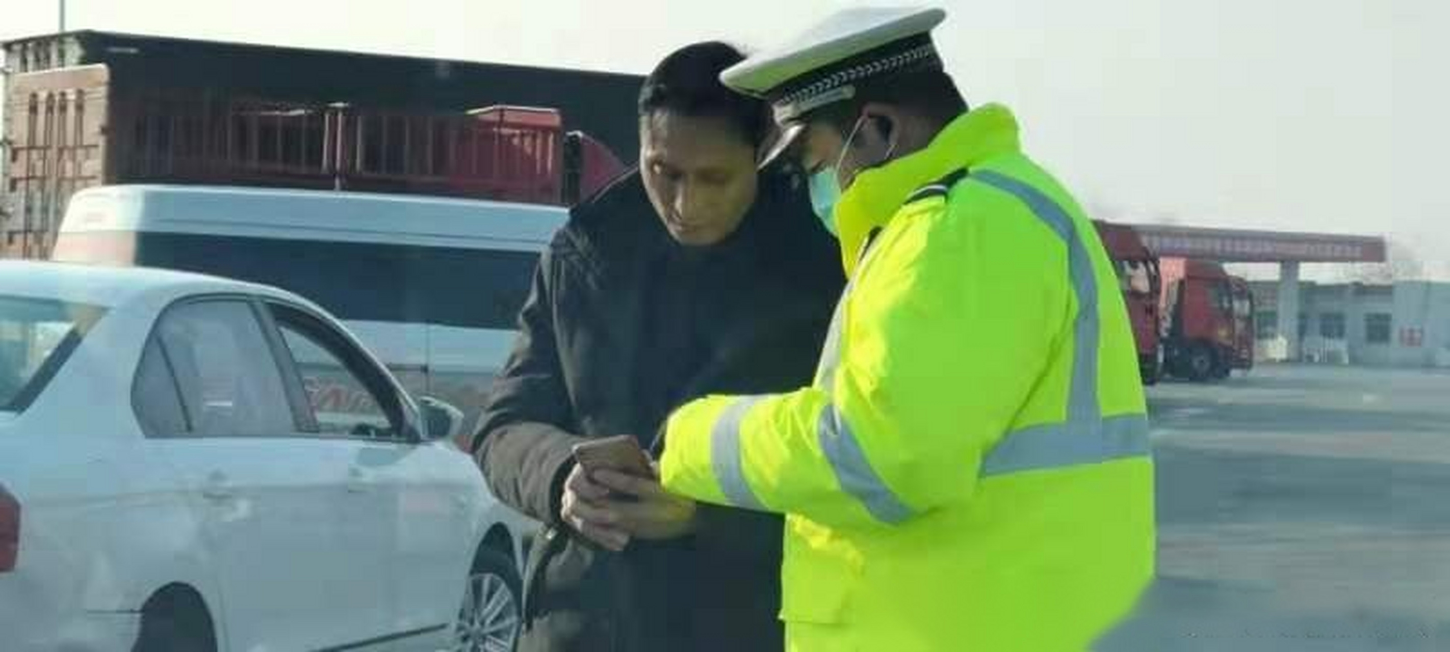藁城大队辅警杜瑶瑶正在耐心给事故当事人讲解12123的使用方法.