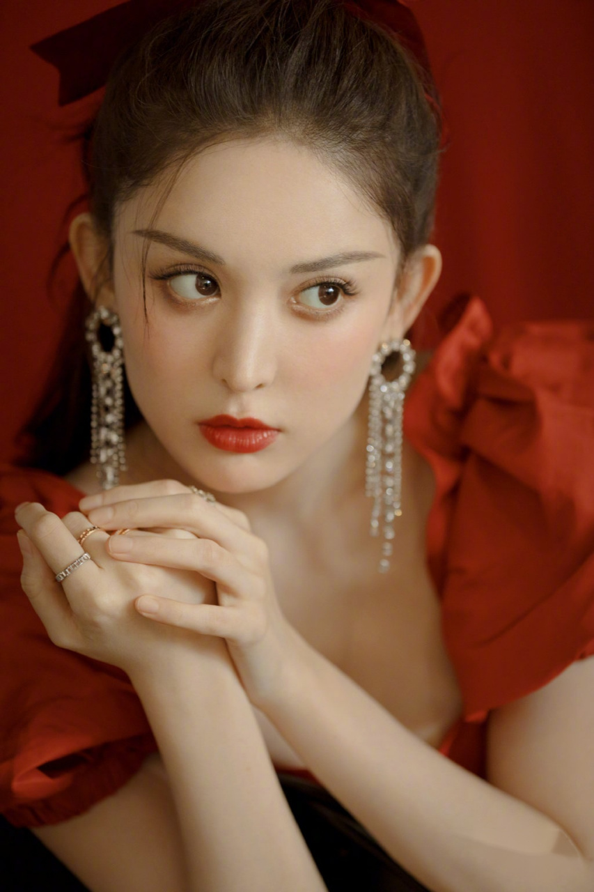 娜扎身着红色花苞袖连衣裙,头发系着丝绒蝴蝶结,同色系的精致妆容,再