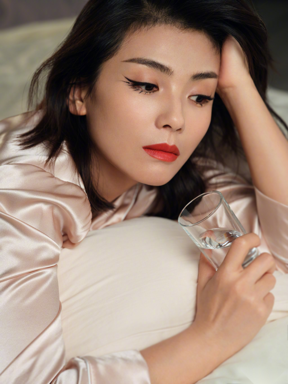 刘涛将眼妆下部分着重描了黑色眼线,穿着粉色绸缎睡衣,搭配烈焰红唇