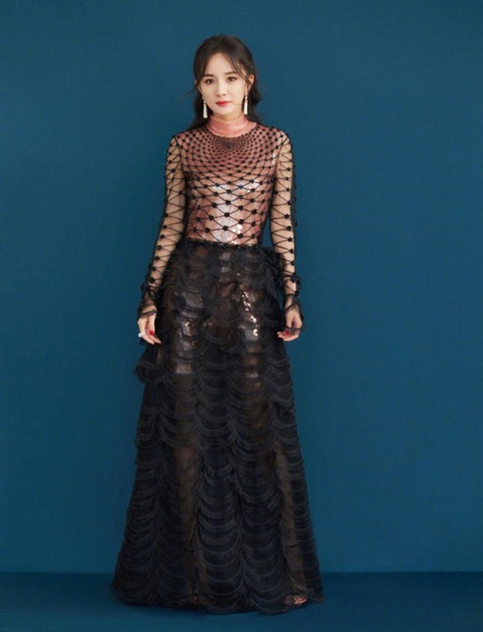 杨幂在2018微博之夜中的造型,身穿一袭黑色透视礼服,透明的亮片隐隐约